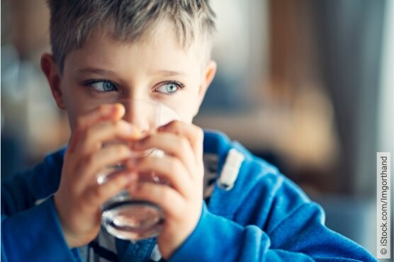 Junge trinkt Wasser gegen Reizhusten.