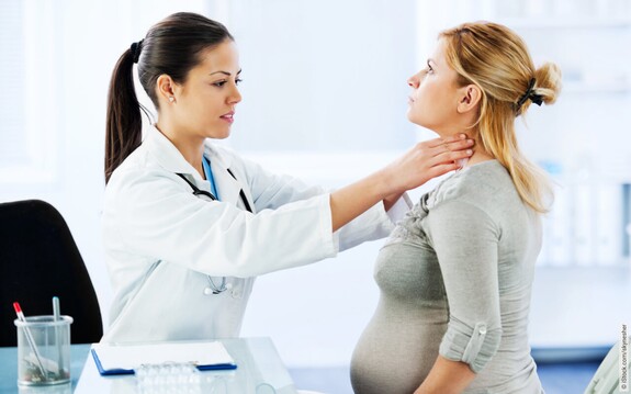 Eine Frau mit Halsschmerzen in der Schwangerschaft beim Arzt.