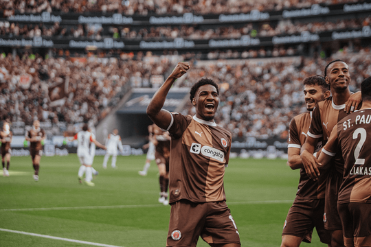 Ein Spieler des Fc St. Pauli bejubelt im Stadion ein Tor.