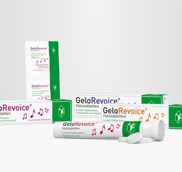 Verschiedene Verpackungen und eine geöffnete Tube von GeloRevoice® Halstabletten in verschiedenen Sorten, darunter Holunderblüte-Menthol und Kirsch-Menthol. Die Produkte stehen auf einer weißen Fläche vor einem grauen Hintergrund. GeloRevoice® lindert Halskratzen, Hustenreiz und Heiserkeit und unterstützt die Regeneration der Mund- und Rachenschleimhaut.